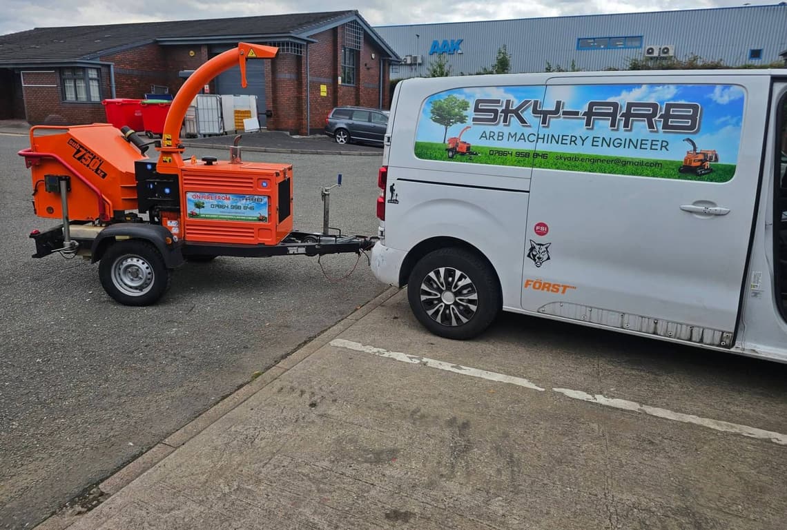 An orange sub-750 kg towable wood chipper coupled to the Sky-Arb van, with an ON HIRE FROM SKY-ARB board fitted