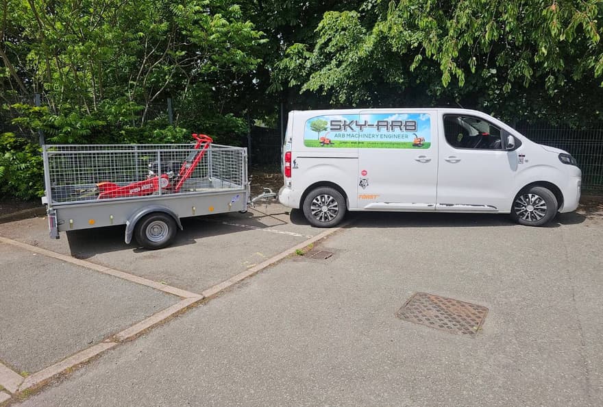 Sky-Arb signwritten van and caged trailer loaded with a stump grinder, ready to leave